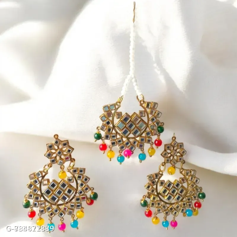 This classic multi-color Jhumka set with maang tika features gold-plated alloy construction adorned with mirror work and vibrant beaded drop